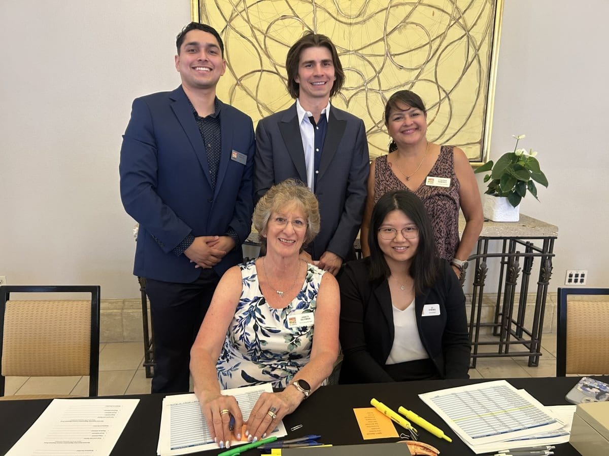 Smiling team behind event registration desk