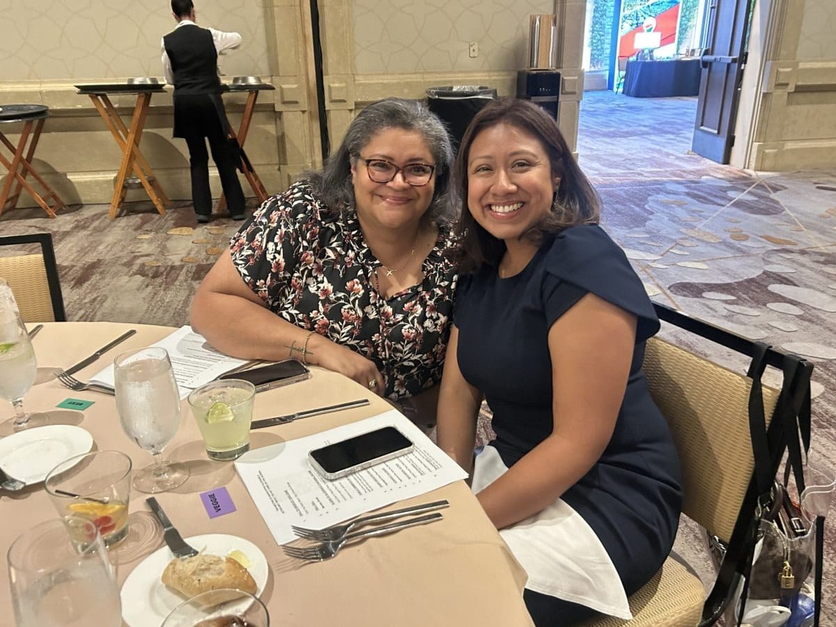 Two women smiling at a dining table
