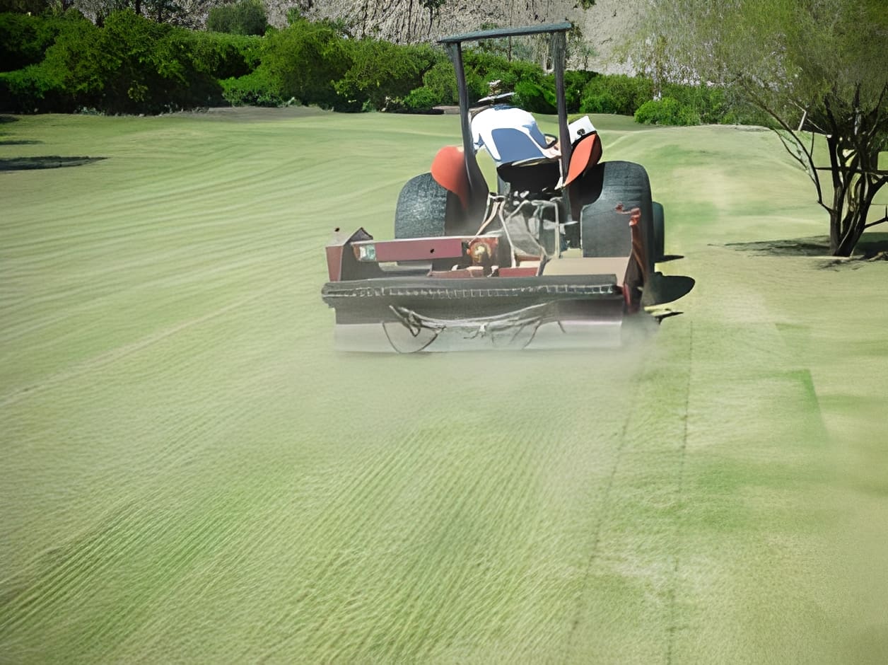 Golf course being maintained by tractor